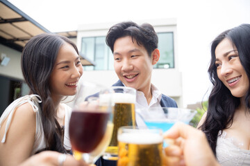 Young asian friends toasting drinks at a party
