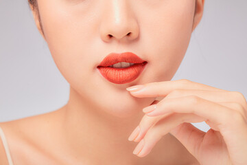 A close view of model showing lip posing with hand for cosmetic advertising