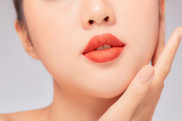 Obraz premium A close view of model showing lip posing with hand for cosmetic advertising