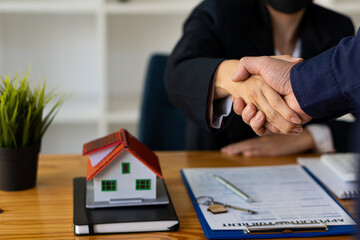 Sales representatives shake hands with customers and offer home purchase contracts to purchase current homes and leases offer homeowners projects upon signing of contract with insurance.