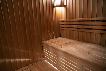 Seat in sauna room. Empty wooden steam room with stone heater.Sauna room for good health. Sauna room with traditional sauna accessories.Healthy and spa life style. High quality photo