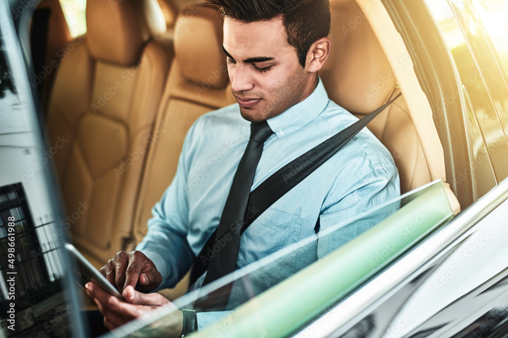 Poster hes got all his tasks saved on one handy device. shot of a young businessman using a digital tablet 