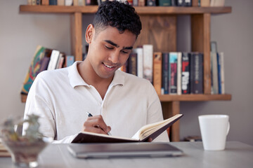 Hard work beats talent if talent doesnt work hard. Shot of an young male writing in his diary at...