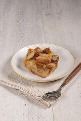 Bread pudding or puding roti tawar topping with almond slice and dried cranberry.