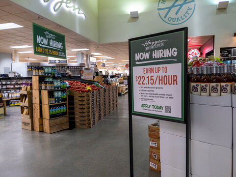 Woodinville, WA USA - circa April 2022: Angled view of a Now Hiring sign inside a Haggen Northwest Fresh grocery store.