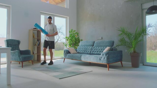 The young handsome man is taking out his dumble from bag and preparing for exercise at home