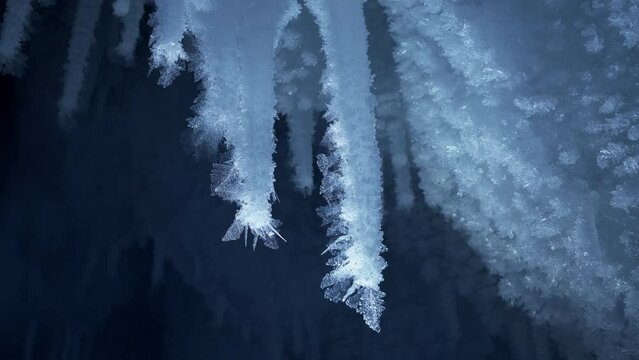 Crystal icicles, sharp ice stalactites, frozen blue ice and snowflakes. Macro 