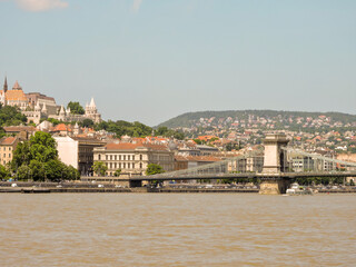 Fototapeta premium Budapest Hungary Wide Brown River From Cruise with Buildings and Bridge