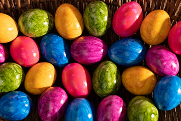 Lots of colorful chicken eggs lying in a basket. Easter.