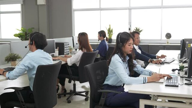 Call center is tired, young adult employee working with headset stretch while working hard, Customer support operator team feeling exhausted and yawning in office, Helpdesk customer services agent