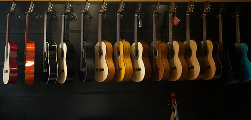 classic guitar drapped in a row in a huge musical shop, instrument shop, instrument concept
