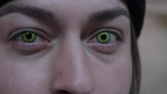 A man opens his eyes to reveal creepy spooky green eyes staring