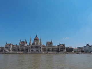 Fototapeta na wymiar Budapest Hungary River Bridge View from Water of ParlIament Castle Building Wide and Blue Sky