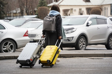Almaty, Kazakhstan - 03.16.2022 : A passenger with luggage goes from the airport building to the parking lot.