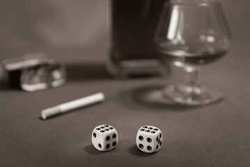 Dice double six, cigarettes and whiskey on table. selected focus, black and white. retro