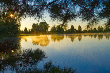 Early morning mist over a tranquil lake at sunrise