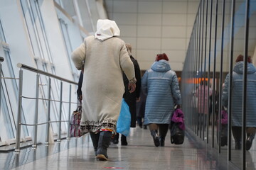 Almaty, Kazakhstan - 03.16.2022 : Passengers with luggage walk along the aisle to the airport...