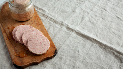 Homemade Jagdwurst on a rustic wooden board, side view. Copy space.
