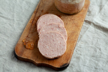 Homemade Jagdwurst on a rustic wooden board, side view.