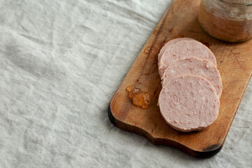 Homemade Jagdwurst on a rustic wooden board, side view. Copy space.