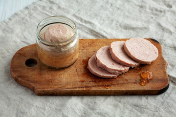 Homemade Jagdwurst on a rustic wooden board, side view.