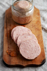 Homemade Jagdwurst on a rustic wooden board, side view. Close-up.