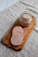 Homemade Jagdwurst on a rustic wooden board, side view.