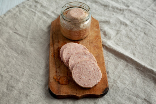 Homemade Jagdwurst on a rustic wooden board, side view.
