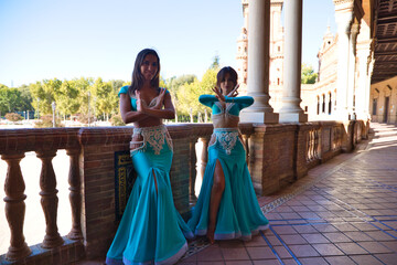 two belly dancers dancing in the place in seville, The dancers are young and beautiful and they are wearing the typical belly dance costume. Concept of dance and regional folklore