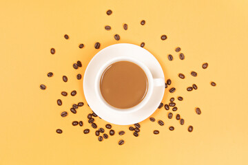 a cup of coffee with coffee beans on yellow background