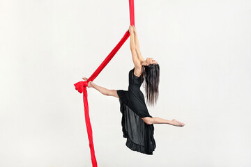 Flexible woman performing trick on aerial silks