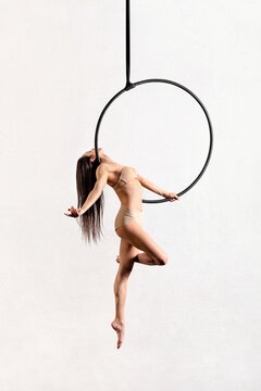 Fit woman performing pose on aerial hoop
