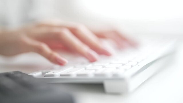 パソコンのキーボードを打つ女性の手元