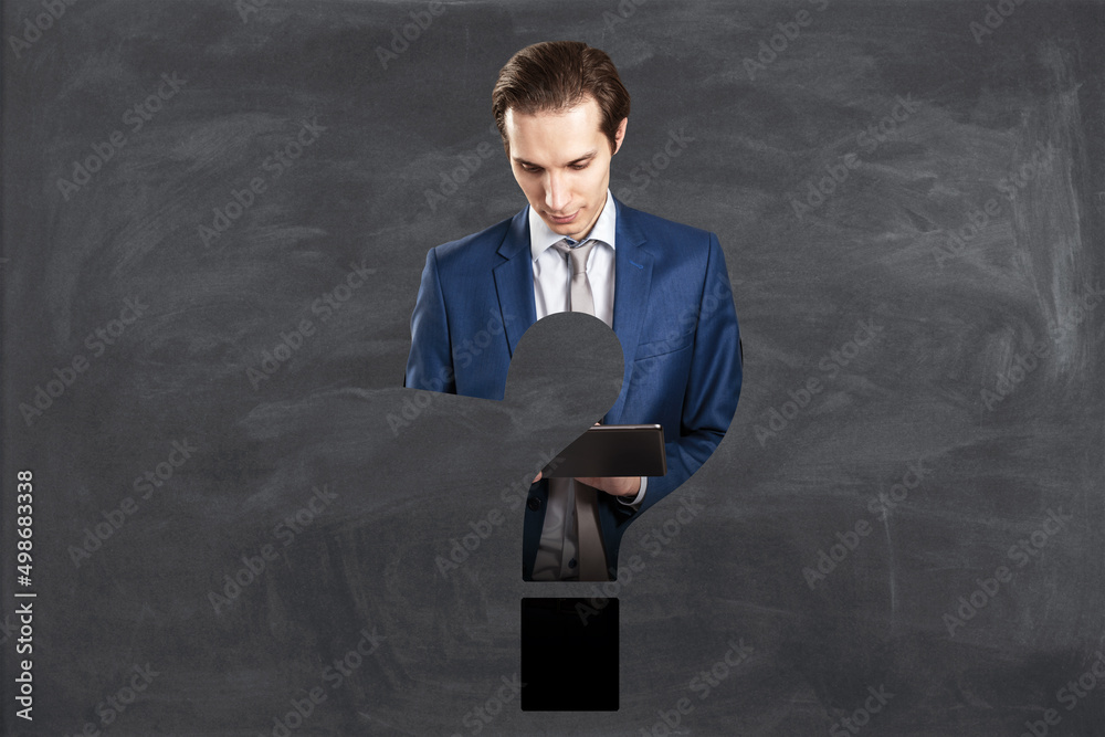 Poster abstract attractive european businessman with tablet and question mark shape on chalkboard wall back