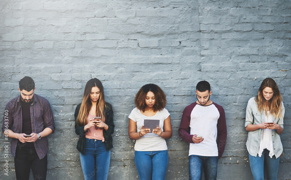 Canvas Prints Meet generation Y. Shot of a group of young people using their wireless devices together outdoors.