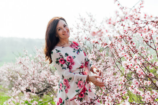 a woman in a garden of flowering trees in the spring