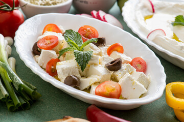 feta cheese cut in cubes, with mint, cherry tomatoes, and olives
