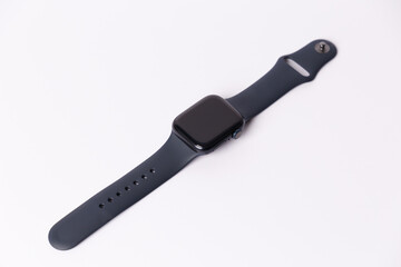 A smartwatch isolated on a white background. Black smartwatch with insulated wrist with open strap. Modern design for high-tech smartwatch and sport technology concept. Close up. Top side view.
