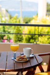 Summer. Breakfast outside by the ocean. Summer vacation in the hotel. Sandwich with coffee and orange juice. Breakfast outside in front of the ocean. Dinner. Food at the hotel. Vacation for one. Food 