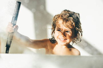 Little girl in shower playing with water.