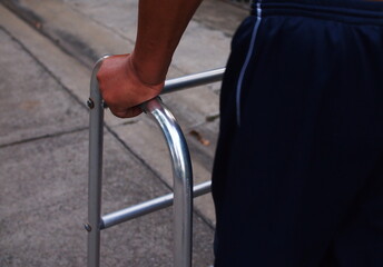 Patient's hand holding a device to assist standing and walking during physical therapy and walking practice.