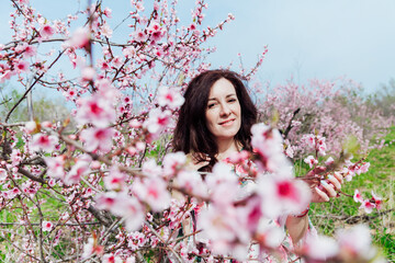 beautiful woman in the garden of flowering peach trees in spring