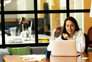 Happy businesswoman working on laptop. Portrait of beautiful businesswoman in the office.