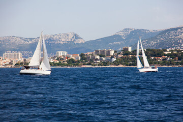 Sailing yachts sail towards each other in the bay.