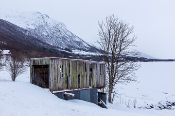 Blokken Norway. 03-03-2022. Old wooden cabin  and snowy landscape at Blokken. Lofoten Islands Norway.
