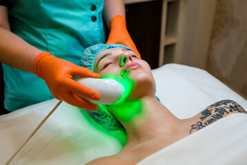 Top view of a charming middle aged European pretty woman receiving an anti-aging rejuvenating...