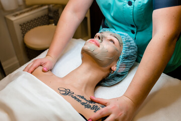 Obraz na płótnie Canvas Beautiful woman having a facial cosmetic scrub treatment from professional dermatologist at wellness spa. Anti-aging, facial skin care and luxury lifestyle concept