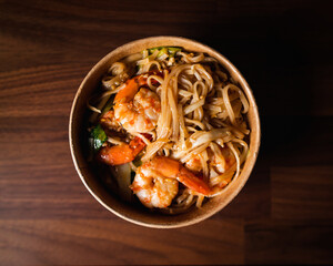 A top view of noodles with shrimps on a wood table