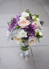 wedding bouquet of natural flowers stands in a glass vase