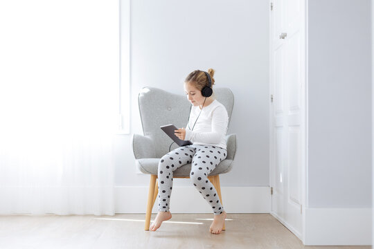 Side view of girl in headphones listening to music